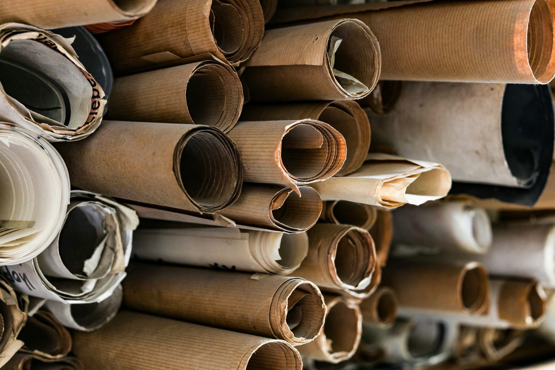 A stack of rolled construction drawings seen end-on, dozens of them.